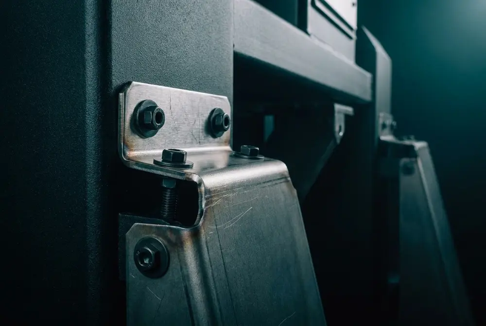 Laser-cut mild steel brackets and guard panels on a machine frame